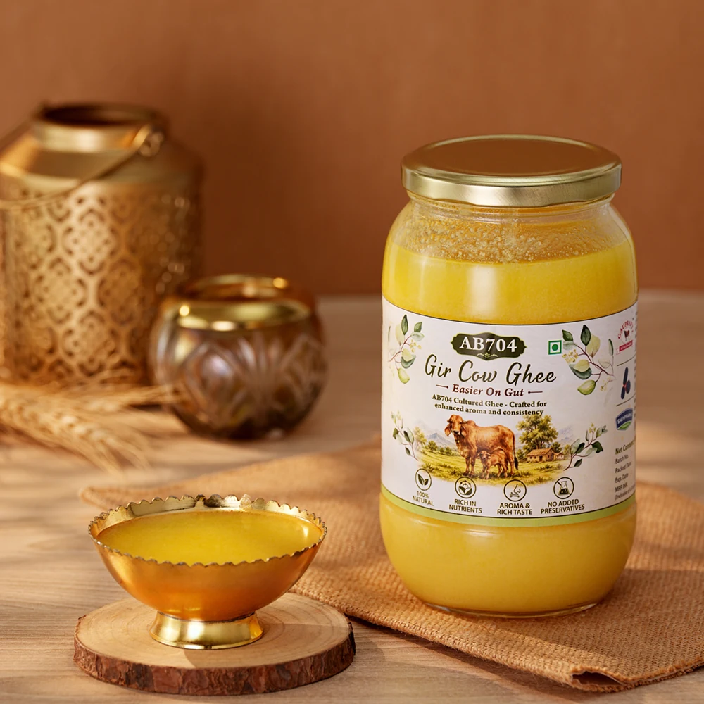 A 1000 ml jar of AB704 beside brass vessels in warm light